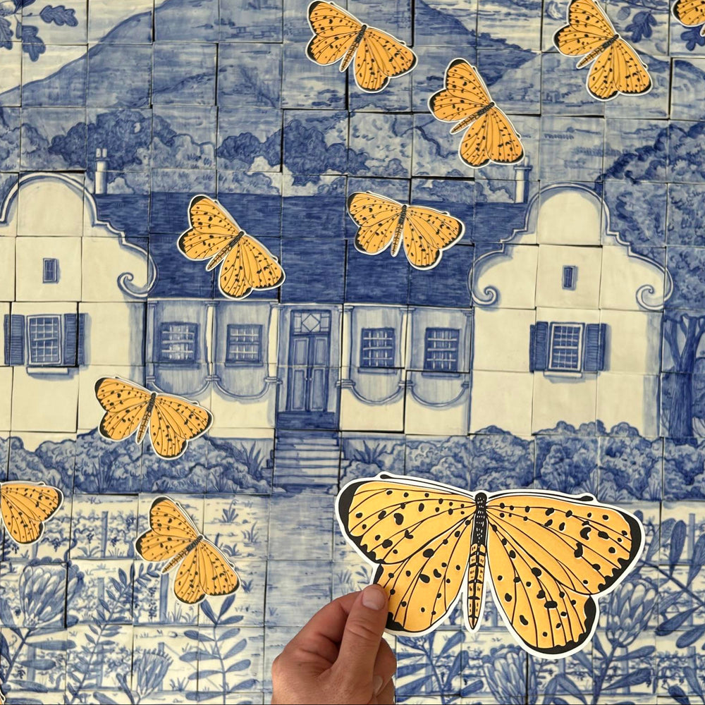 Decorative tile pattern with houses and butterflies, hand holding a butterfly illustration.