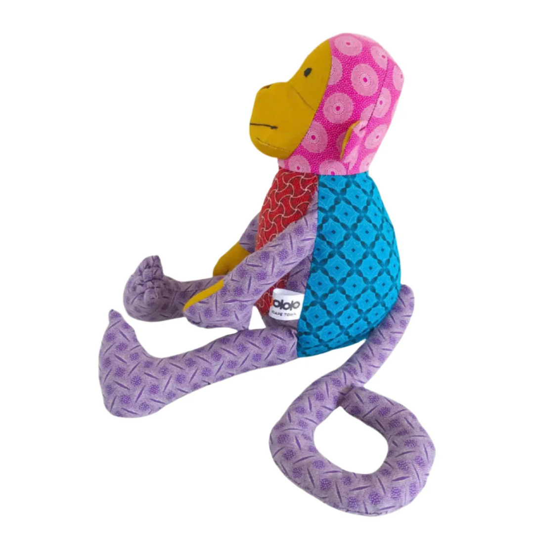 Side of Monkey Shweshwe Stuffed Toy, with colourful fabric on white background