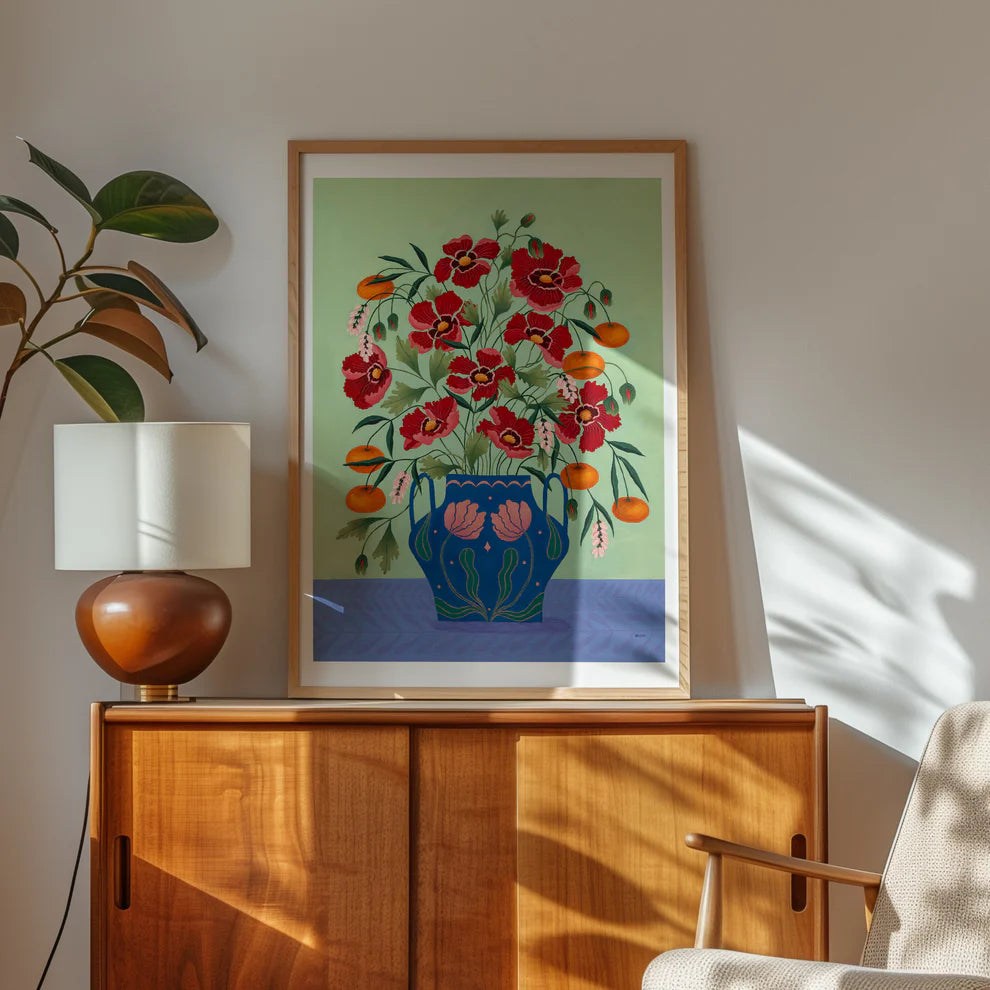 Framed Fine art print of a bright burgundy floral display in a blue vase with light pink floral motif.